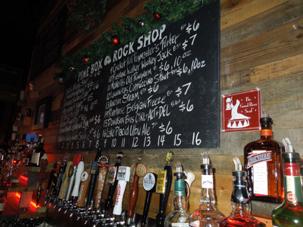 Pine Box Rock Shop bar counter with chalkboard beer menu and craft beer bottles, circa 2013