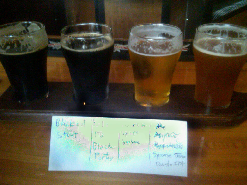 Beer flight at Sugar Maple in Milwaukee circa 2011, featuring stout, IPA, black porter, and amber ale samples on wooden...