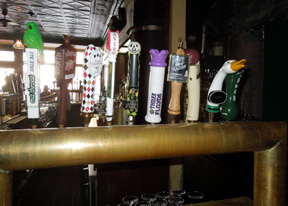 Multiple beer taps on Hopleaf Bar's brass tap handle rail, Chicago, 2012