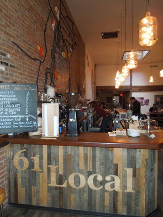 61 Local bar counter with wooden front panel, pendant lights, and chalkboard menu, circa 2013