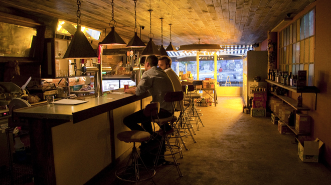 Patrons seated at bar counter inside Mugs Alehouse, Williamsburg Brooklyn, circa 2013