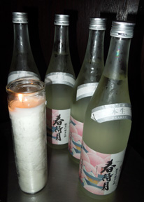 Sake bottles and a glass of sake beside Japanese beer bottles, circa 2012, illustrating Japan's brewing traditions...