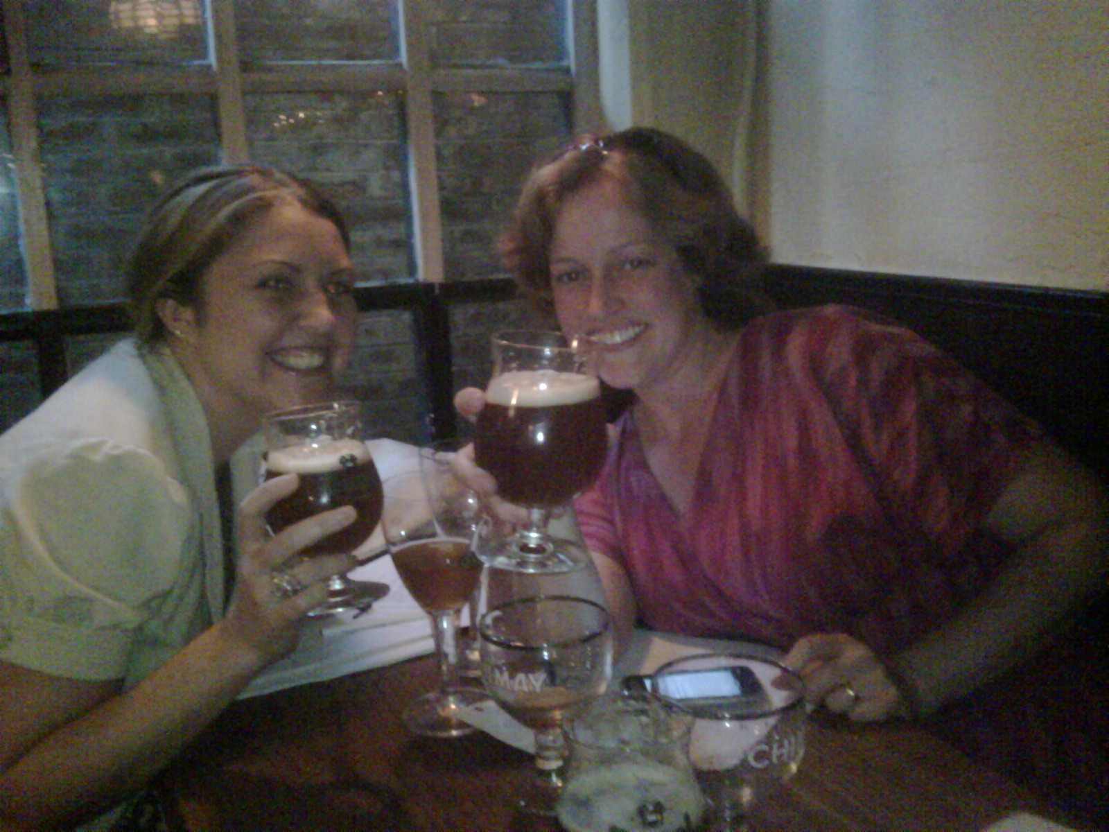 Two women toasting with craft beers at a bar, circa 2010, celebrating Good Beer Seal staff work